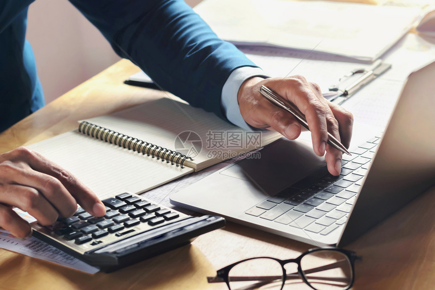 税收在办公室会计概念财务中使用计算器和机的办公桌上从事工作的商业者金融的笔记本电脑图片