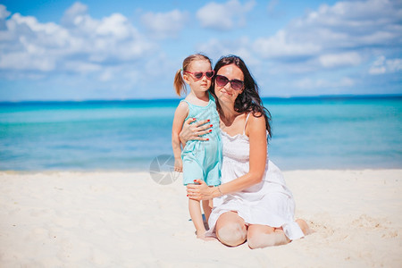 年轻美丽的母亲和她小女儿在海滩上美丽的母亲和女儿在海滩上享受暑假快乐的父母海洋图片