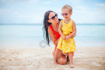 白种人年轻美丽的母亲和她小女儿在海滩上美丽的母亲和女儿在海滩上享受暑假快乐的欧洲图片