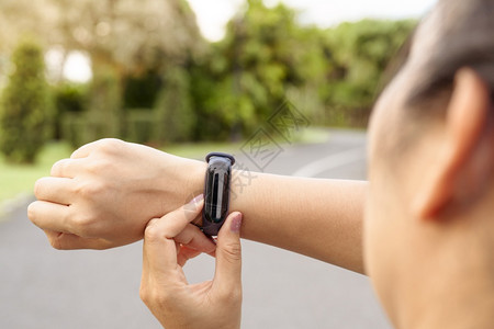 运动的城市合身健女运动员在开展户外锻炼活动前设置智能手表运动图片