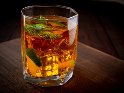 液体酒精鸡尾加威士忌柠檬和冰在黑暗背景酒精鸡尾加威士忌柠檬和冰一种酸橙图片