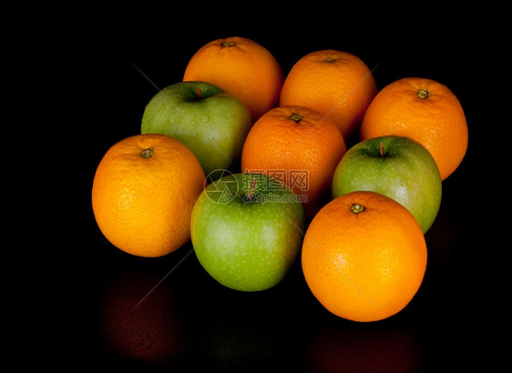黑色上隔离的苹果和橙子多汁的纸浆图片