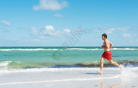 水沿着海岸跑的年轻男子肌肉人们图片