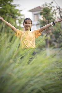 绿色身体可爱的在青绿花园中亚洲青少年手签署胜利的图片