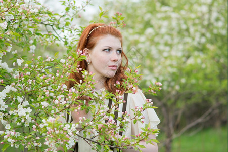 浪漫肖像乡村的可爱红头发女孩走进苹果园图片