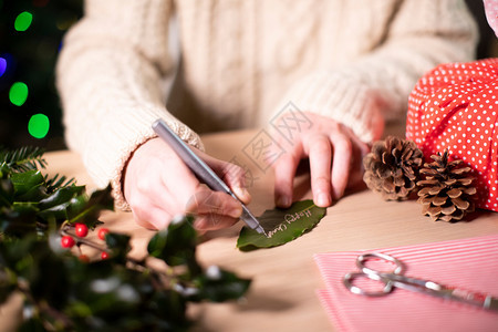 妇女写从BayLeaf制作的礼物标签以换取对生态友善的圣诞礼物环境的保护圣诞节图片