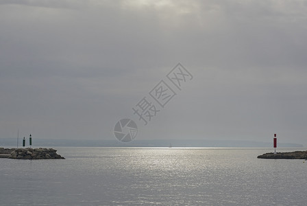 蓝色的港口岩石1月西班牙马洛卡Mallorca以帆船和阳光在两座码头之间开通时用帆船和阳光观视海洋图片