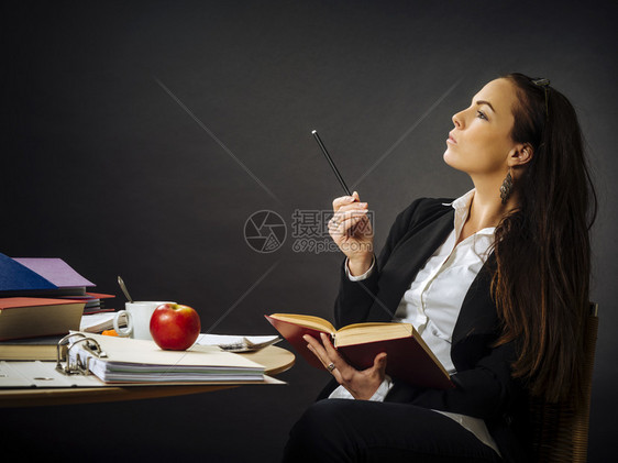 照片来自一位教师或女商人她身着30rsquots的30rcops坐在一张桌子前的大黑板思想面前老师学生吸引人的图片