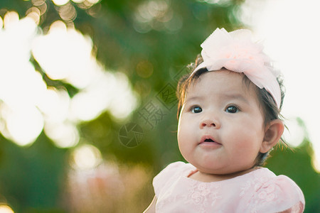 近身肖像亚洲可爱的有自然光背景女婴情感晴天头发图片