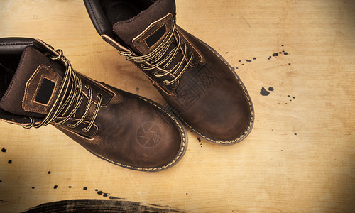一种撕开时髦的Brownmenrsquos靴子木制背景与世隔离的Menrsrcopos棕色靴子和蓝牛仔裤被孤立图片