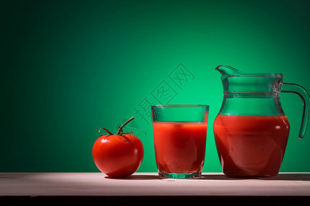 维他命生的香菜番茄玻璃和加汁的壶子在绿色背景的番茄杯子和加汁的罐子上图片