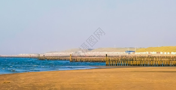 海岸线在多姆堡滩有许多木质的风电杆泽兰和内地旅行游的图片