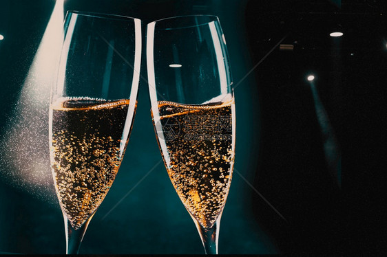 两杯香槟和节假日灯新年庆祝会典眼镜金子玻璃图片