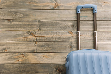 以木制背景的蓝色旅行李箱成熟蓝色的数字化图片
