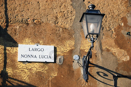姓名阴影边界在典型的Bolgheri街上道名称和一条小街灯图片