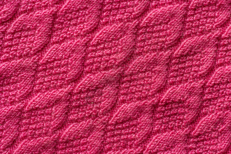 服装粉红色编织物背景或纹理的一块针织线条手工制作的一块粉红色编织物背景或纹理手工编织毛衣图片