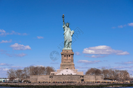 绿色国民蓝天下自由神像曼哈顿纽约市建筑和带有旅游观光概念建筑和图片