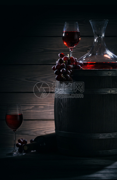 桶在黑暗的地窖里用红酒喝着色葡萄酒的永生在黑暗的地窖里围绕一个主题红酒魔法轻光面包圈脱盐器和杯子红酒在黑暗的地窖里新红色图片