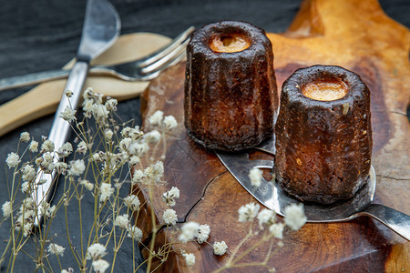 木头香肠和朗姆酒的小糕饼在木制盘子上装满了朗姆酒和香草传统法国甜点从顶端看可吃图片
