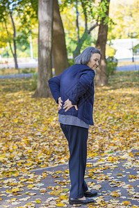 户外背部疼痛的老年妇女图片