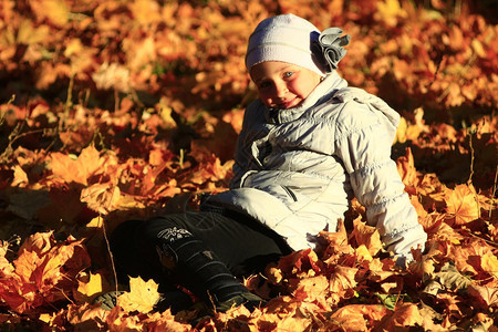 躺在落叶堆里可爱的小女孩图片