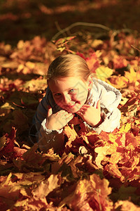 和平小女孩躺在秋天公园的黄色树叶上幸福童年图片