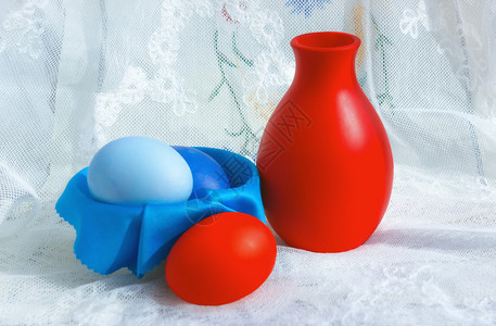 重点优质的选取对浅地彩色复活节鸡蛋和A卷的抽奖器着眼点在白旧蕾花桌布上绘制红色和蓝复活节鸡蛋和陶瓷刺表蕾丝图片