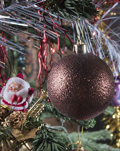 前景树上的圣诞球在背景中树枝上的圣诞老人球的身影和背景中圣克劳斯身影大气层玻璃幸福图片
