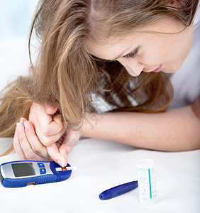 测量血糖的女青年图片