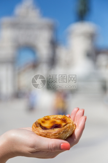 在葡萄牙里斯本的背景点上葡萄牙传统妇女手中的Pasteisdenataspathesnata女传统的甜点图片