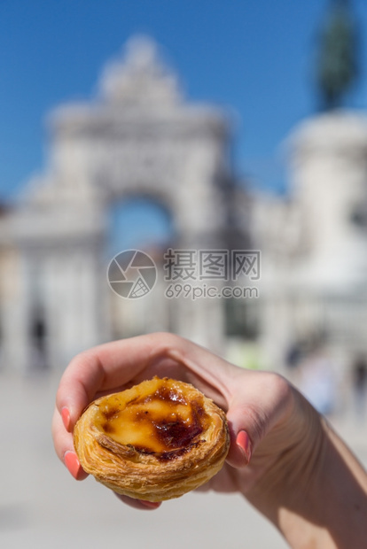 粉彩午餐在葡萄牙里斯本的背景点上葡萄牙传统妇女手中的Pasteisdenataspathesnata美味的图片