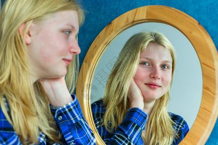 反光的金发十几岁荷兰女孩看着镜子思维眼睛图片