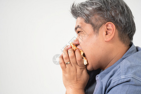 不良身体亚洲中年男子持有和吃汉堡包美味极了狂喜饮食紊乱的BED概念以吃垃圾食品和不健康来放松年轻的图片