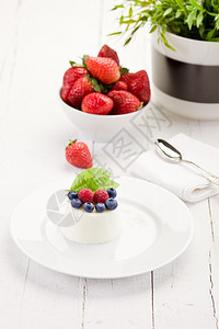 甜点蓝莓白木桌边有浆果的美味pannaCotta照片牛奶图片