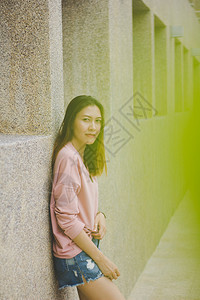 亚洲人自然办公室身穿粉红衬衫靠在建筑物墙上的女人图片