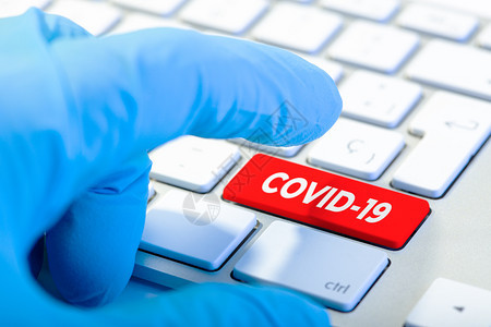 与保护手套和持红色钥匙COVID19信息Corona概念的键盘并肩保护手套和键盘关心健康工作图片
