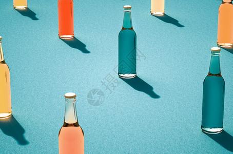 满的广告关闭各种彩色玻璃瓶子防止浅蓝色表面装满无标签的全杯和封闭玻璃瓶背面反tro饮料瓶影子概念的混合式玻璃瓶气泡图片