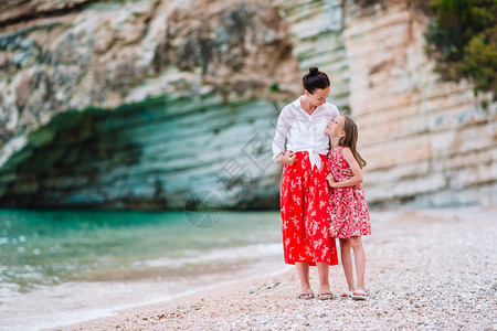 海岸线热带滩上的家庭母亲和小女孩享受假期母亲和小女儿在热带海滩享受时光丰富多彩的白种人图片