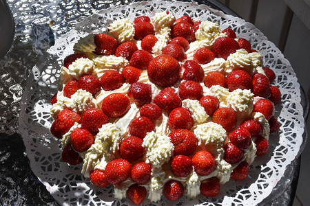 圆形的桌子美丽夏日蛋糕桌边有草莓和奶油浆果图片