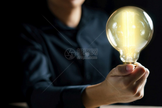 发光的有创造力男人手握着灯泡概念的充满灵感思维图片