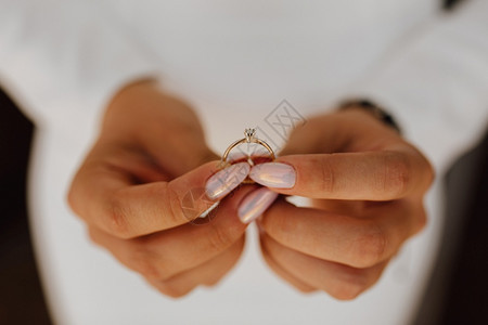 吸引人的妻子保持新娘带着订婚戒指与钻石握在手上美的修甲前视结婚日图片