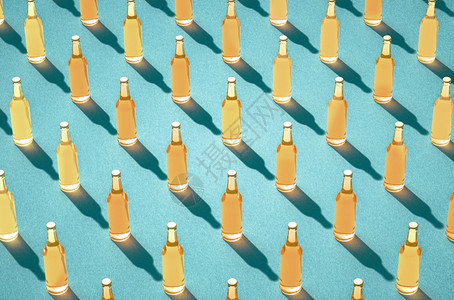 盛满的啤酒瓶排以对抗浅蓝色表面的轻啤酒瓶装满的玻璃瓶没有标签长阴影回声饮料瓶概念各种样的气泡新鲜图片