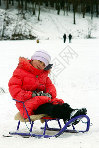 圣诞节快乐的坐在红色羽毛床上的雪橇漂亮女孩坐在雪橇上的漂亮女孩冷静图片