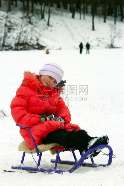 圣诞节快乐的坐在红色羽毛床上的雪橇漂亮女孩坐在雪橇上的漂亮女孩冷静图片