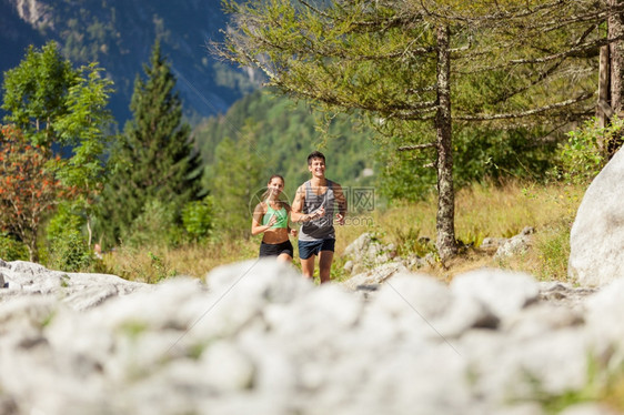 微笑健康年轻运动夫妇在山上奔跑的相片慢图片