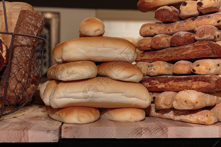 早餐品种木制板上的面包卷和法式小叶子典型的图片