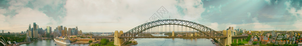 海岸线码头日落时悉尼港桥从澳大利亚天空看望水图片