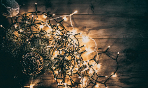 木制复古背景上的圣诞灯问候装饰电灯泡图片