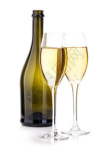 两杯香槟放在棕色瓶子的背景上紧地隔离在白色上喜庆的金子干杯图片