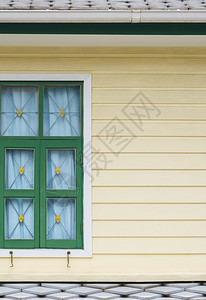 雨水口抽象的质地黄木墙上绿窗部分色口在垂直架状的2层古老故事屋中有灰砖顶图片